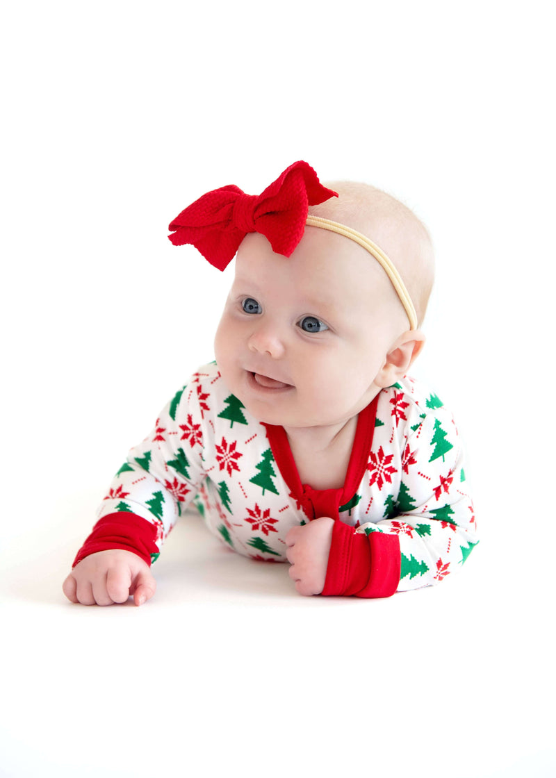 Minky Couture Infant Unisex Zipper Footie worn by a smiling baby with a red bow, festive holiday outfit.