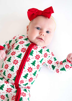 Minky Couture Infant Unisex Zipper Footie worn by a baby with a red bow, featuring festive holiday patterns.