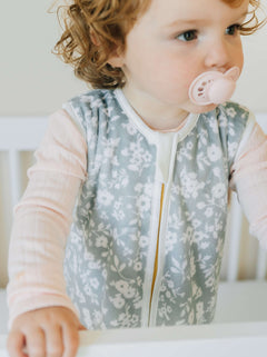 Minky Dainty Floral Sage Wearable Blanket on a cute child in a crib, promoting safe sleep for infants.
