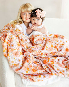 Boho Floral Blanket featuring girls snuggled under a colorful flower design with peach minky backing.
