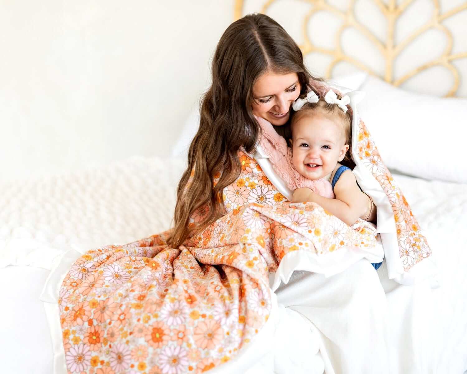 Mom and child cozying up with a Boho Floral Blanket featuring vibrant flowers and a plush backing.