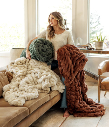 Lindsay Arnold holding Minky Couture blankets in green, cream, and brown
