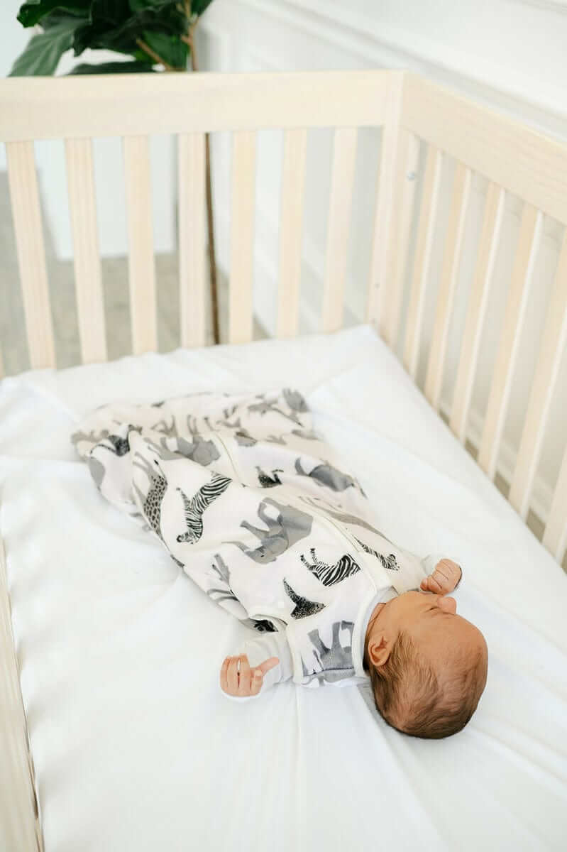 Baby sleeping on Minky Crib Sheet in a crib, showcasing cozy comfort and softness of the Crib Sheet.