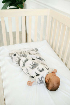Baby sleeping on Minky Crib Sheet in a crib, showcasing cozy comfort and softness of the Crib Sheet.