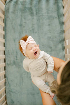 Cozy baby yawning in crib on Minky Crib Sheet, showcasing ultimate comfort and softness for sleepy times.