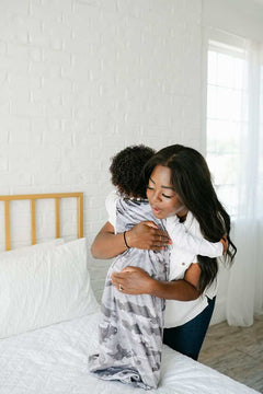 Camo Wearable Minky Blanket cozy hug between mother and child in a stylish bedroom setting.