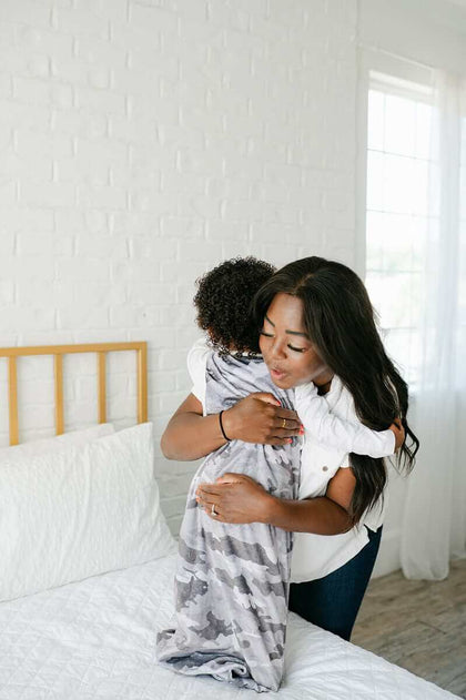 Camo Wearable Minky Blanket cozy hug between mother and child in a stylish bedroom setting.