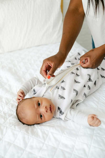 Mountains Wearable Minky Blanket being zipped up on a baby, highlighting safe sleep and cozy comfort.