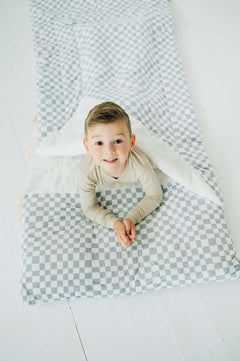 Child inside Sleeping Bag Sage Check, showcasing cozy Minky Couture design with stylish check pattern.