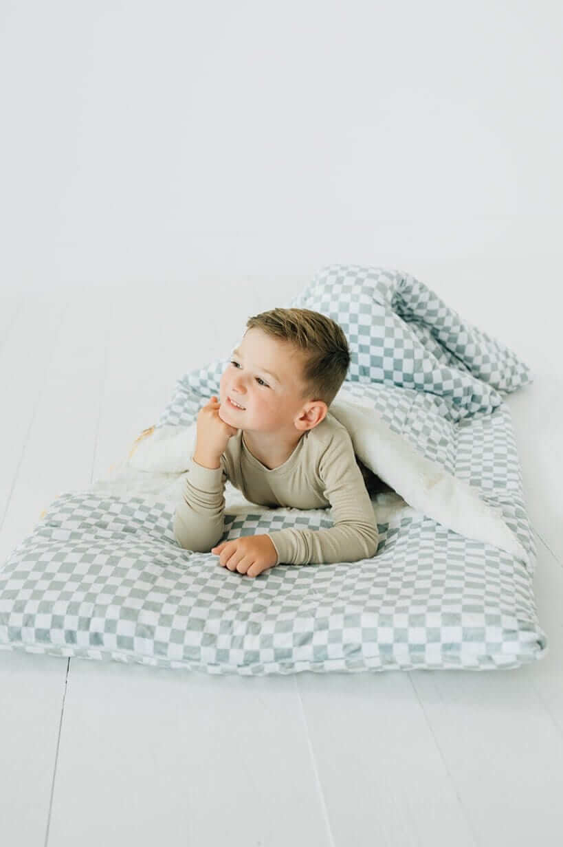 Child enjoying the Sleeping Bag Sage Check with a cozy design and plush lining.