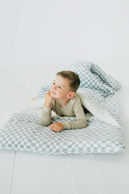 Child enjoying the Sleeping Bag Sage Check with a cozy design and plush lining.