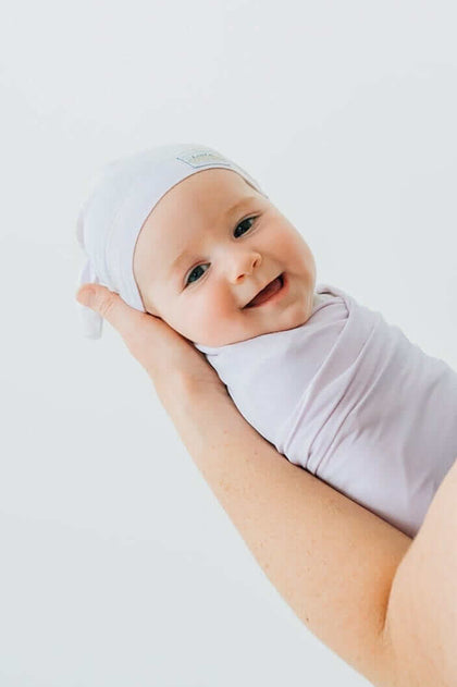 Adorable baby wrapped in Lavender Swaddle and Hat, showing cozy and soft bamboo fabric for comfortable sleep.