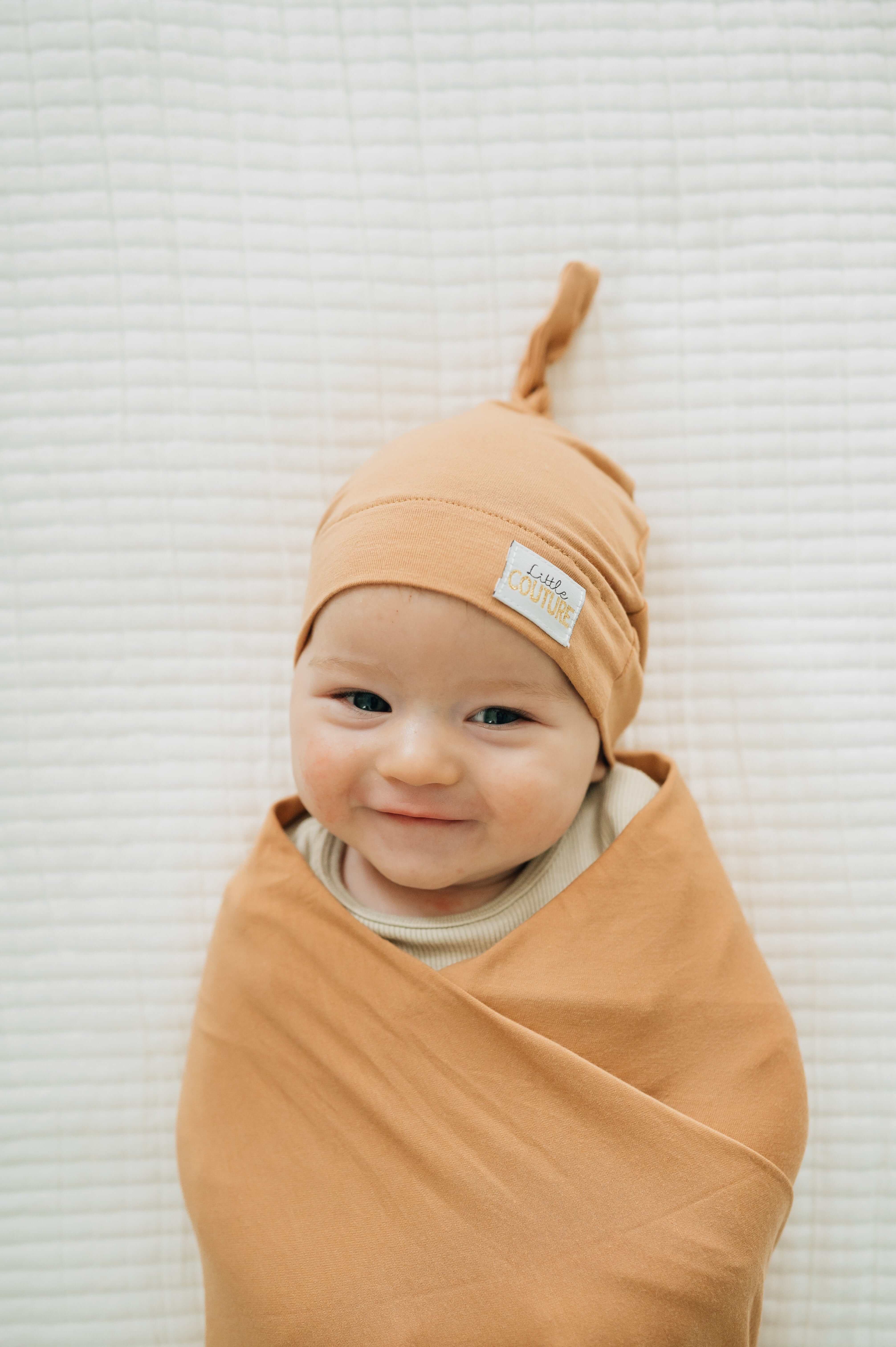 Swaddle and Hat Baked Apple Pie with a smiling baby wrapped in a soft bamboo swaddle and hat.