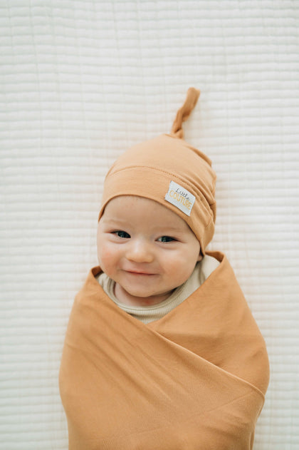 Swaddle and Hat Baked Apple Pie with a smiling baby wrapped in a soft bamboo swaddle and hat.