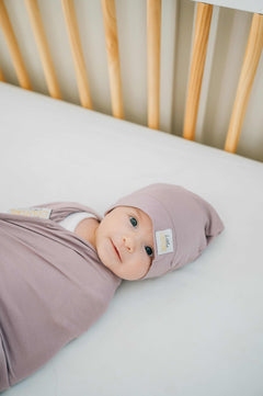 Swaddle and Hat Blueberry Cheesecake combo with a cozy baby in a crib, wrapped in soft bamboo fabric.