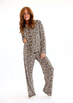 Woman standing in a Minky Couture leopard print pajama set with a tie waist on a white background.