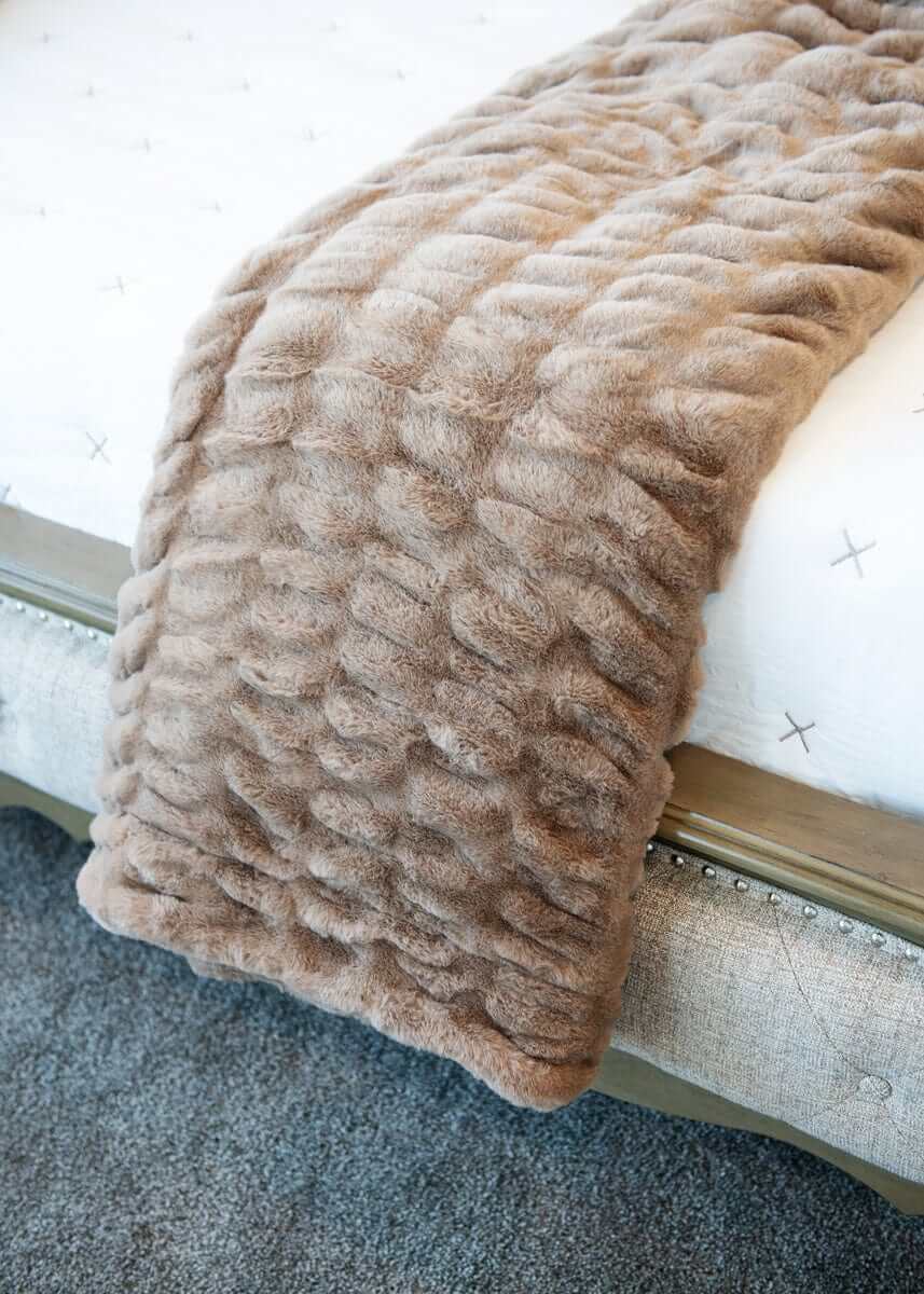 Minky Couture Hugs Milk Chocolate Minky Couture weighted blanket draped over a bed.