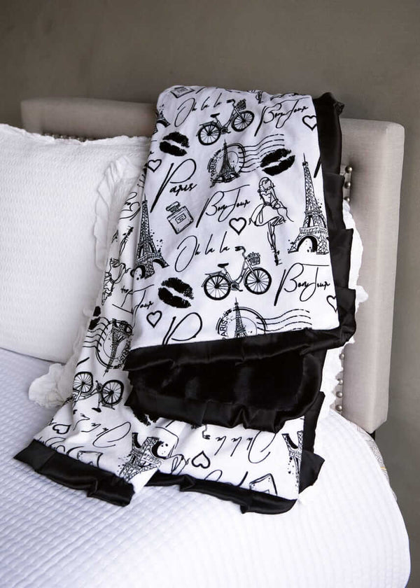 Patterned blanket with Paris-themed design on a white surface.