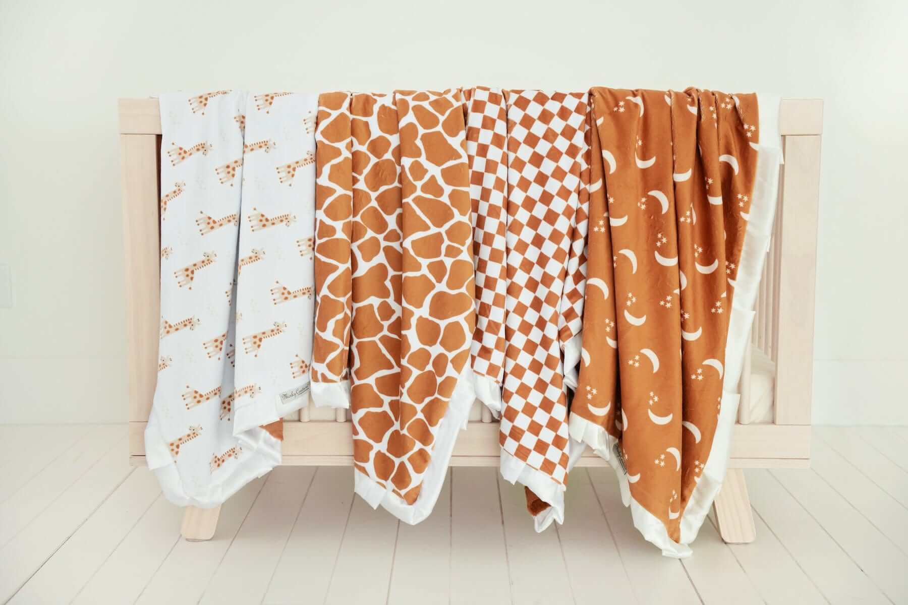Minky Couture Blankets displayed among other cozy blankets on a wooden rack.