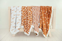 Minky Couture Blankets displayed among other cozy blankets on a wooden rack.