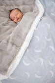 Baby sleeping peacefully under the Minky Couture Shining Moon Silver Blanket featuring soft gray and dreamy moon design.