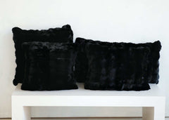 Black Cloud Sham faux fur throw pillows arranged on a white shelf.