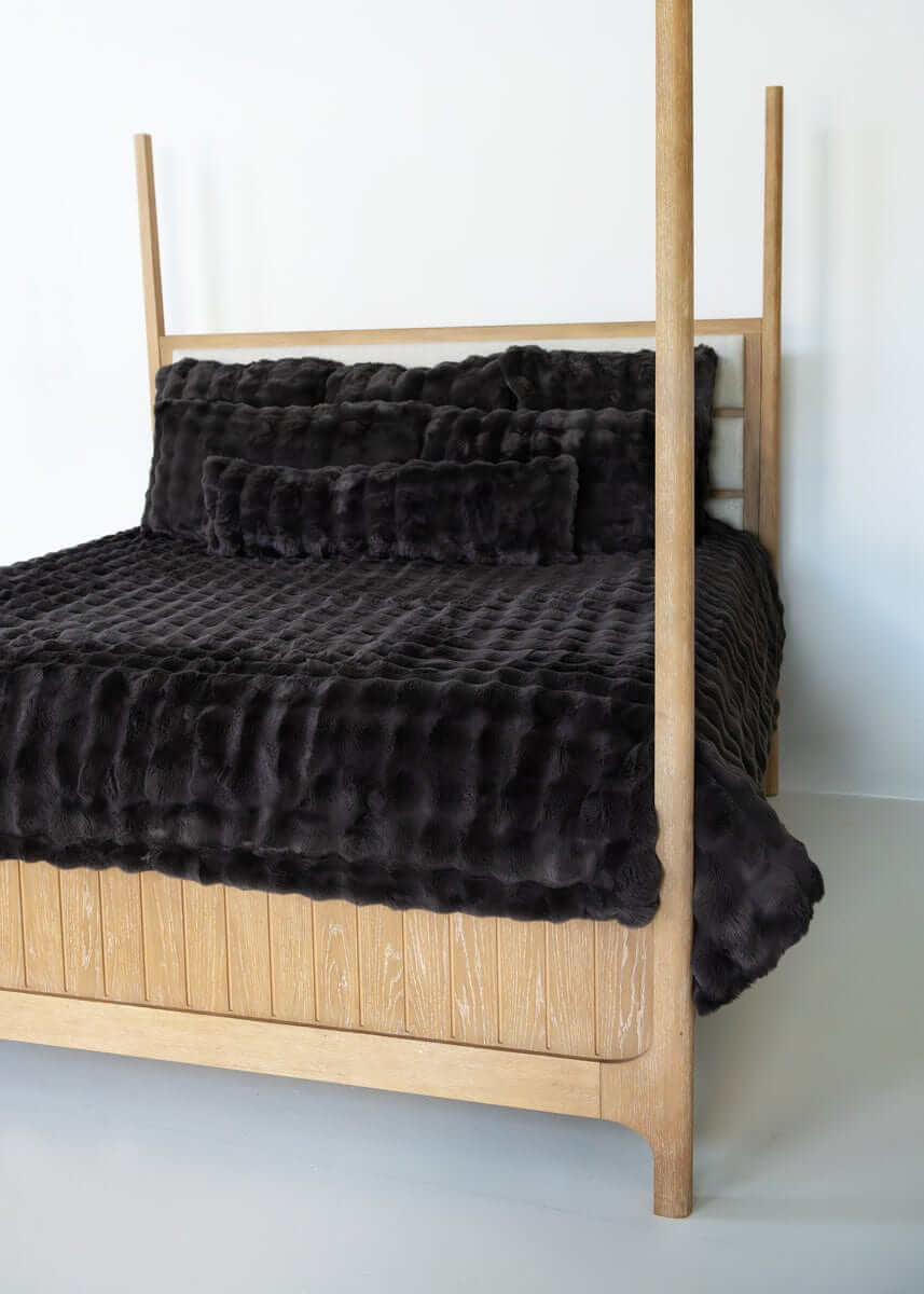 Charcoal Cloud Minky Couture duvet and pillows styled on a wooden canopy bed against a white background.
