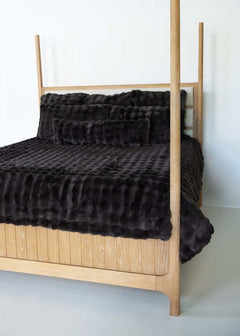 Charcoal Cloud Minky Couture duvet and pillows styled on a wooden canopy bed against a white background.