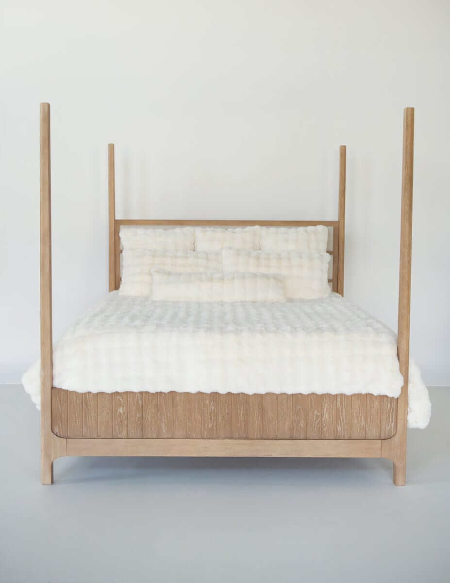 Wooden bed frame with Cream Cloud Duvet bedding and matching pillows against a neutral background.