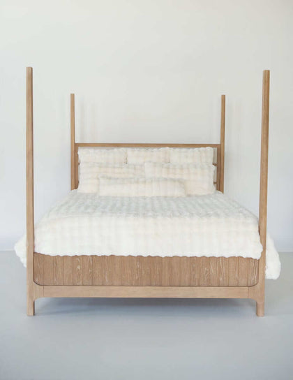 Wooden bed frame with Cream Cloud Duvet bedding and matching pillows against a neutral background.