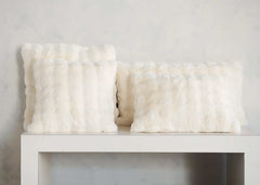Minky Couture Cream Cloud Sham faux fur throw pillows arranged on a white shelf.