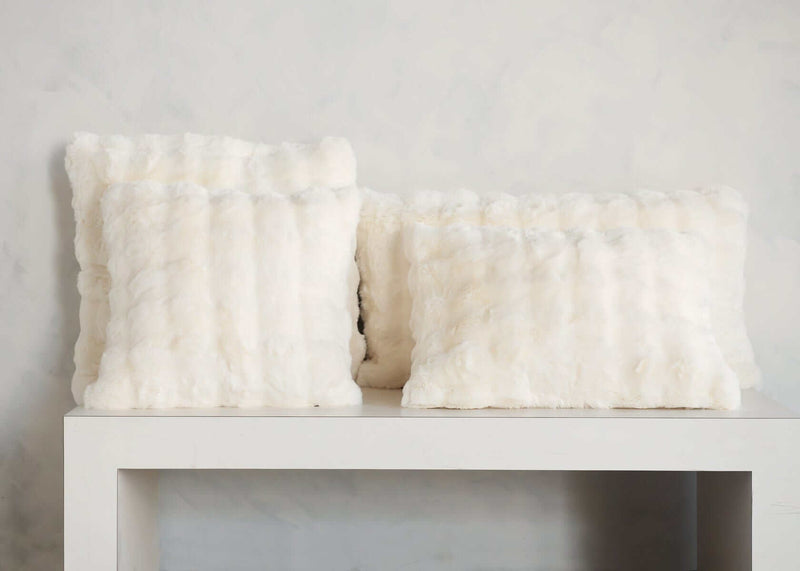 Minky Couture Cream Cloud Sham faux fur throw pillows arranged on a white shelf.