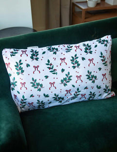 Christmas Pillowcase featuring festive patterns of holly and bows on a decorative pillow.