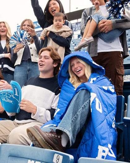Minky Couture BYU Cougars Hooded Stadium Blanket keeping fans warm at a game with cozy design and vibrant colors.