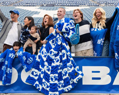 Minky Couture BYU Cougars Blanket being enjoyed by fans at a game, showcasing team spirit and cozy design.