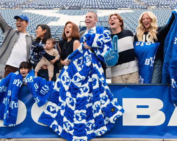 Minky Couture BYU Cougars Blanket being enjoyed by fans at a game, showcasing team spirit and cozy design.