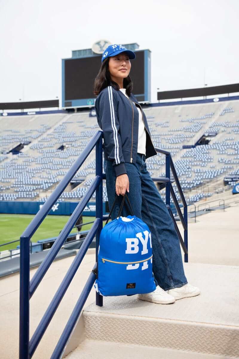 BYU Cougars Hooded Stadium Blanket displayed by a fashionable model in a stadium setting.