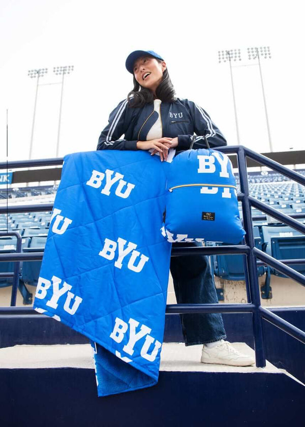 Minky Couture BYU Cougars Hooded Stadium Blanket displayed at a stadium, showcasing its bold blue color and logo.