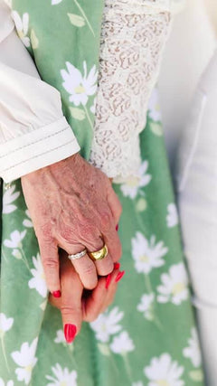Sage Wildflower Blanket draped, showcasing hands with rings and bright nails, enhancing the floral design.