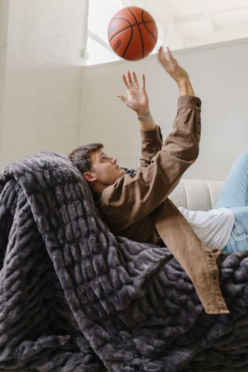 Walker Kessler on a charcoal Minky weighted blanket while tossing a basketball.