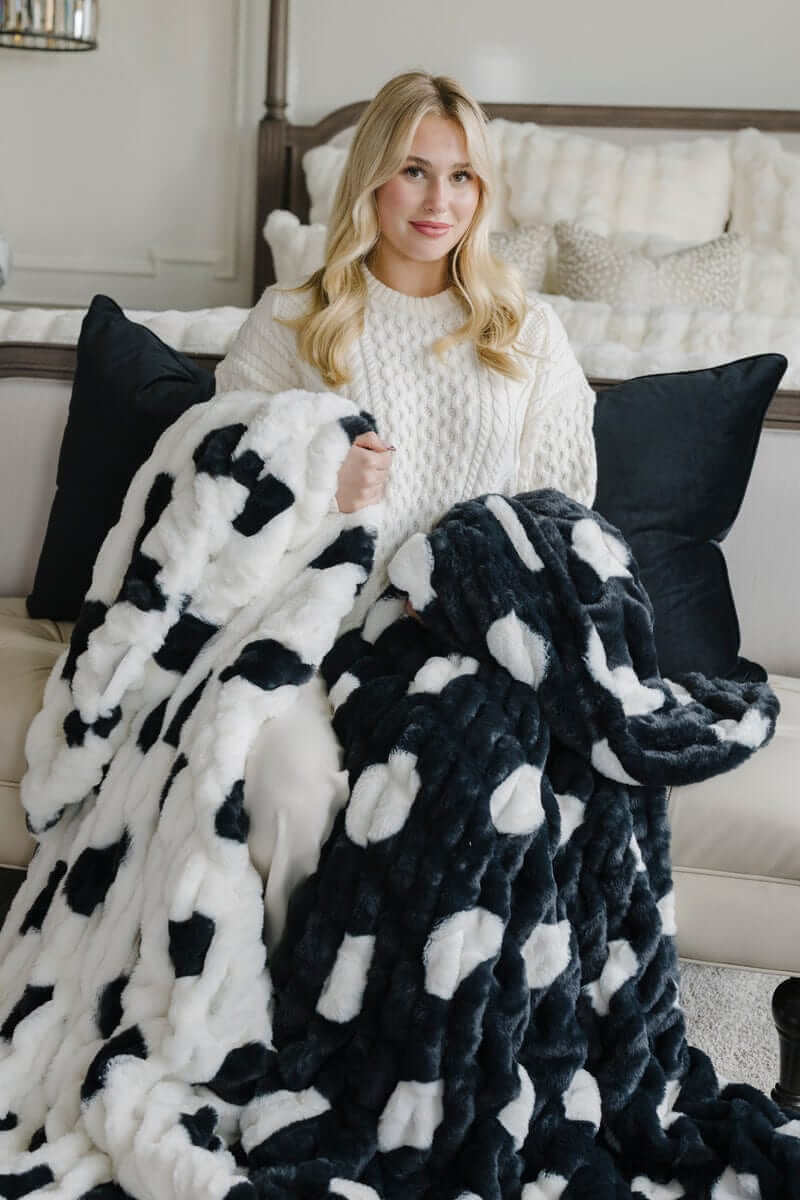 Woman sitting with white and navy polka dots patterned Minky blankets.