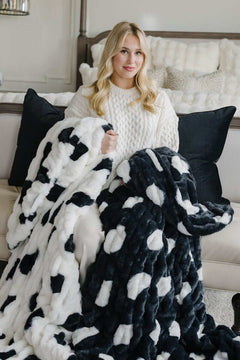 Woman sitting with white and navy polka dots patterned Minky blankets.