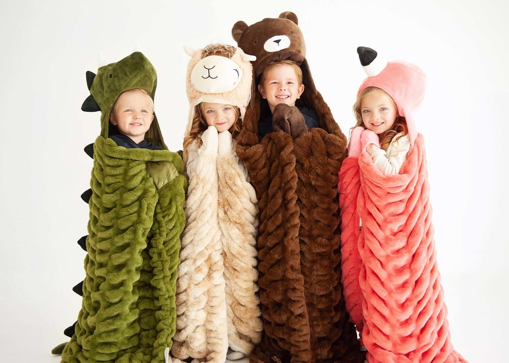 Kids wrapped in cozy blankets featuring Huggable Dino and other fun animal designs, perfect for imaginative play.