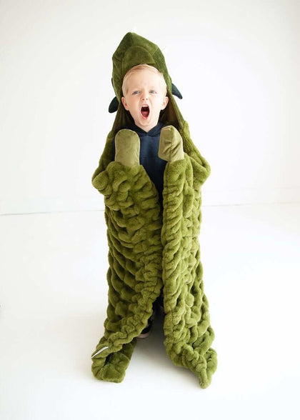 Child wrapped in Minky Couture Huggable Dino green blanket, excitedly embodying a playful dinosaur.