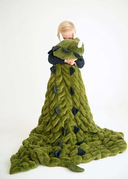 Child wrapped in Huggable Dino green blanket, featuring dinosaur spikes and a cozy design for playful adventures.