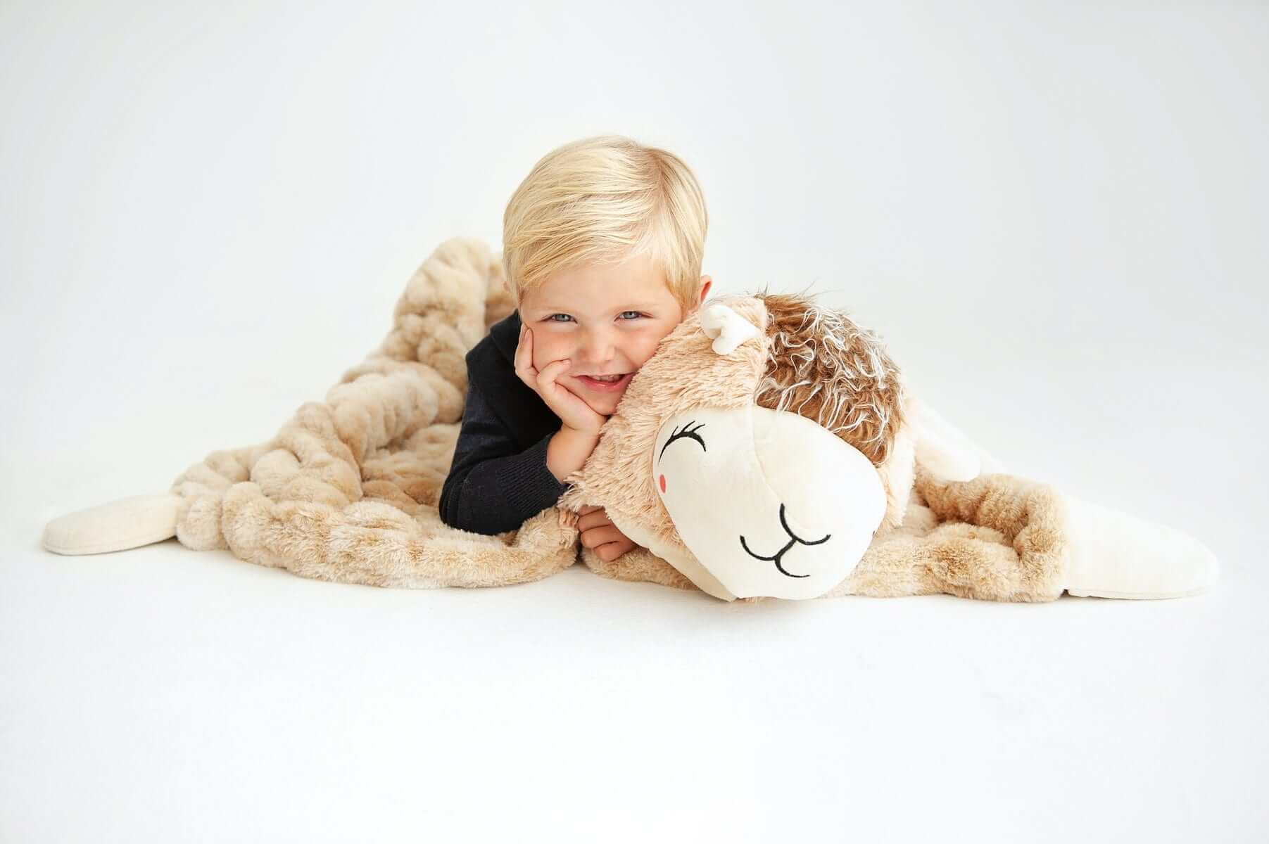 A happy child cuddles with the Huggable Llama blanket, showcasing its cozy and adorable design.