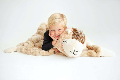 A happy child cuddles with the Huggable Llama blanket, showcasing its cozy and adorable design.
