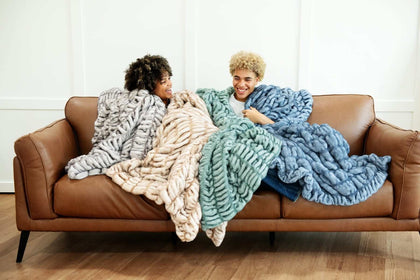 Cozy moment with the Hugs Blankets, featuring plush faux fur in warm tan and blue colors, ideal for relaxation.