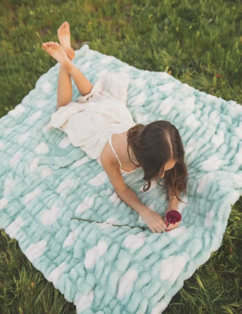 Child relaxing on the Minky Couture Hugs Polka Dot Tiffany Blanket with cream polka dots.