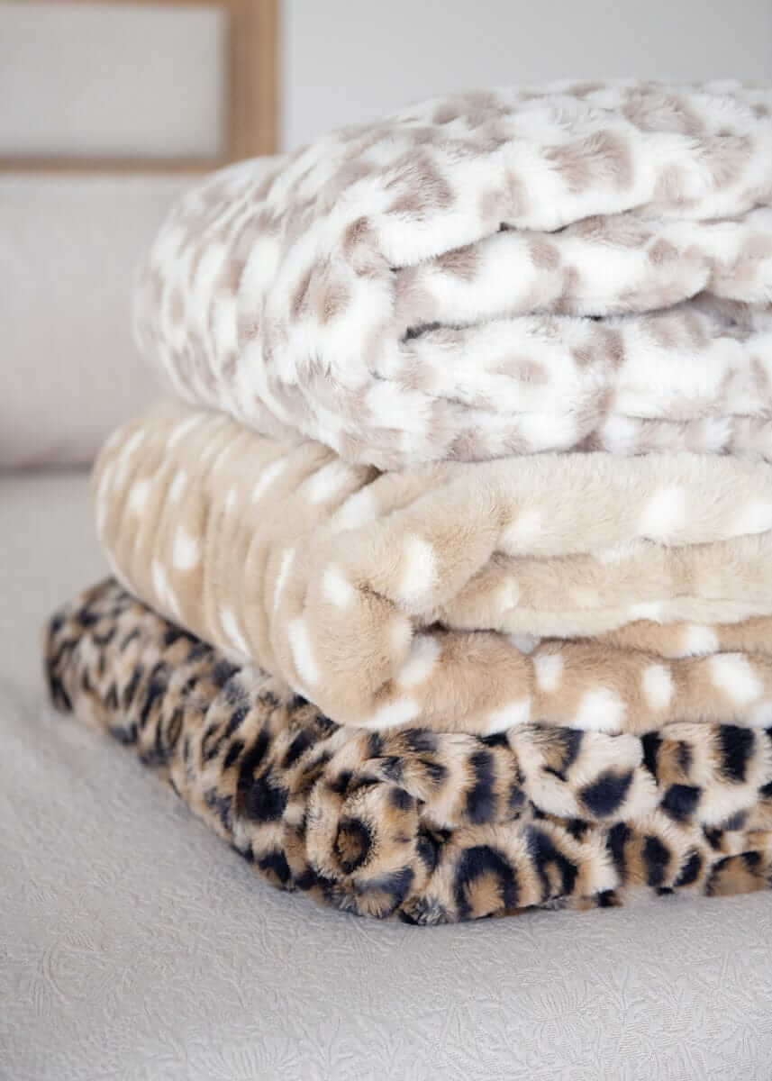 Folded Minky Couture blankets in snow leopard, tan spotted, and leopard prints.